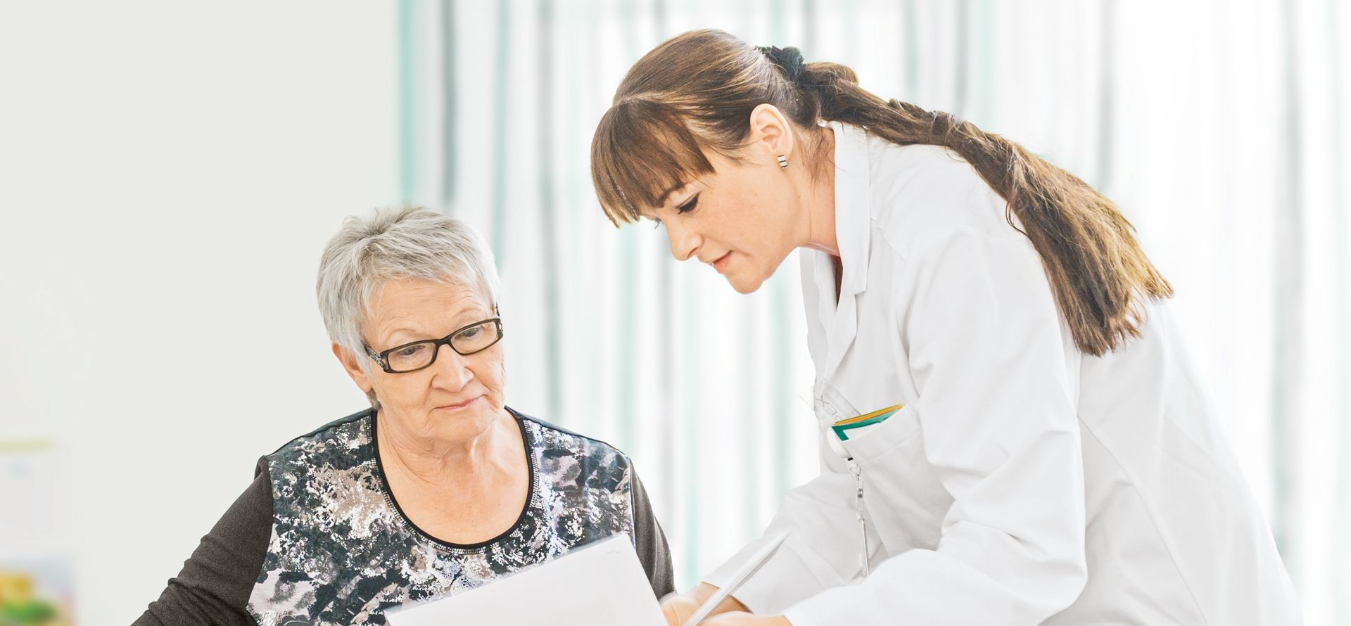 Ärztin erklärt Patientin Unterlagen
