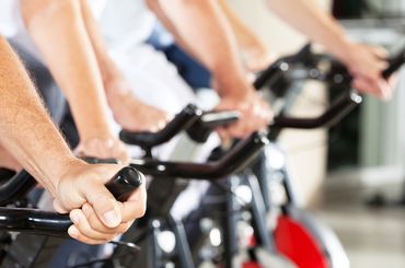 Personen trainieren auf einem Hometrainer
