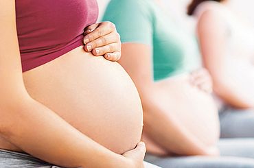 Frauen berühren ihren Schwangerschaftsbauch