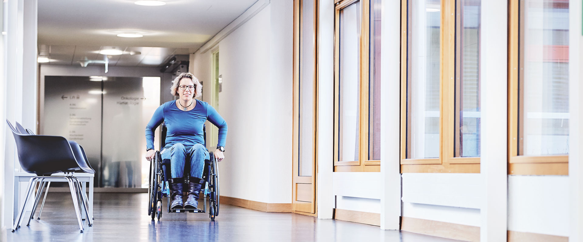 Nicole Häusler fährt im Rollstuhl durch die SRO AG