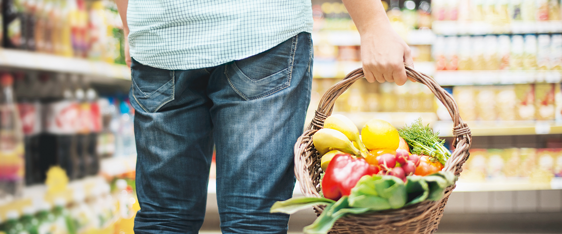 Mann trägt Korb mit frischem Gemüse und frischen Früchten