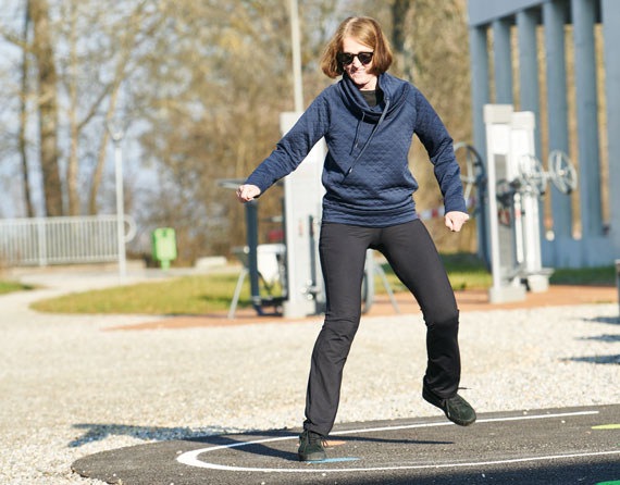 Patientin trainiert an den Outdoor Fitnessgeräten